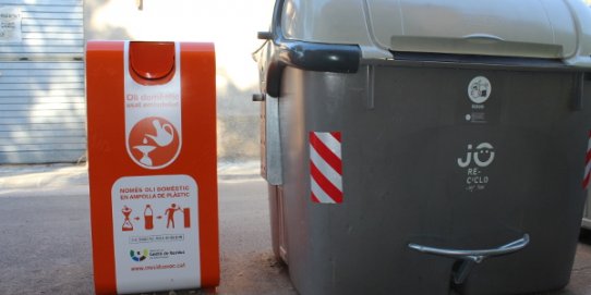 Imatge del contenidor d'oli del carrer de Caldes, situat al costat d'un contenidor de rebuig.